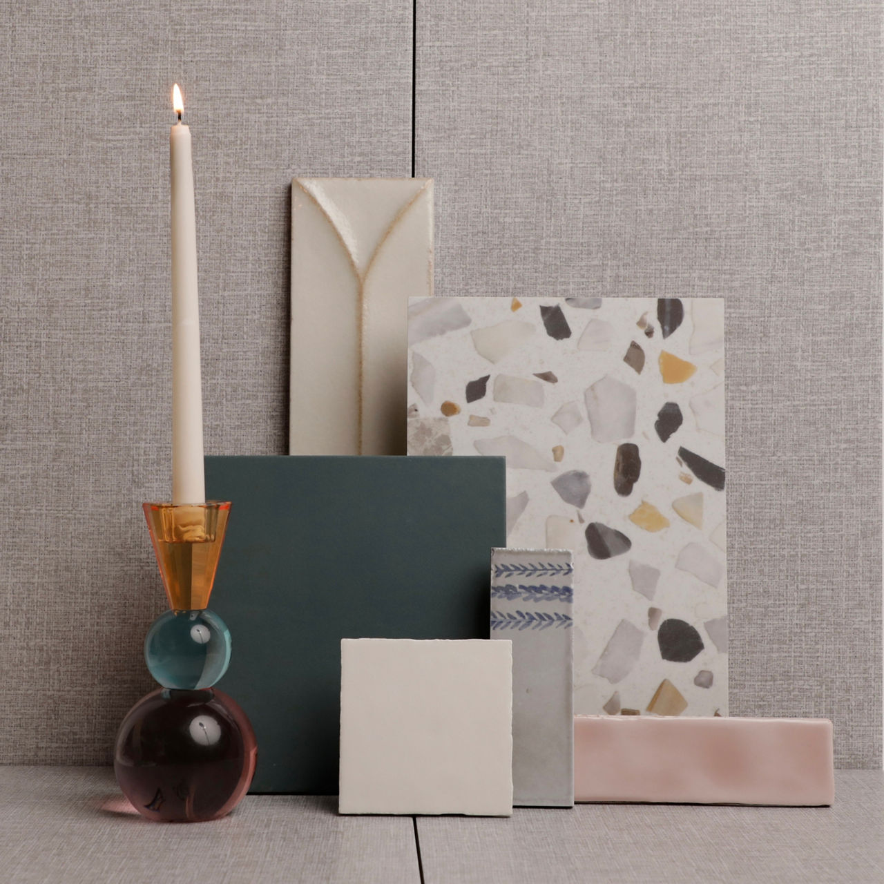 This flatlay contains white rectangle fabric look tile, white terrazzo look rectangle tile, green square tile, white square wall tile, pink rectangle wall tile, white rectangle wall tile with design, and white rectangle wall tile with blue flowers.