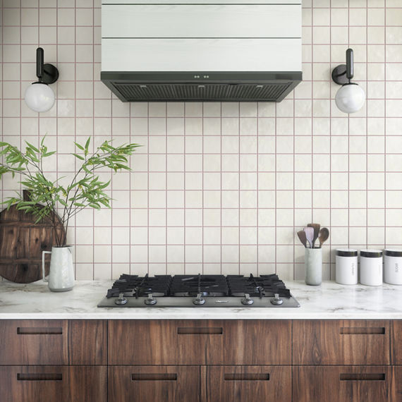 Kitchen with white mosaic square tile on backsplash, wood cabinets, brown grout, and white accents.