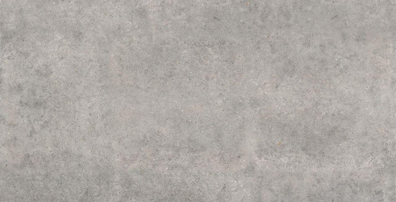 Vertical image of a light gray concrete or stone surface with a subtle mottled pattern. The texture appears slightly rough with small speckles and variations in tone. It resembles a concrete wall, floor tile, or industrial surface. The neutral gray c