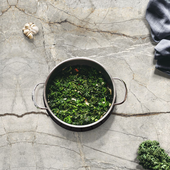 Shiny pots and pans with a grey background, symbolizing a clean kitchen, fresh start, cooking, meal prep, and delicious food.