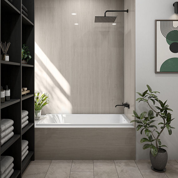 Bathroom with a beige stone look slab on shower walls, white tub, beige stone look rectangle floor tile, dark wooden shelves, and small plants throughout the room.