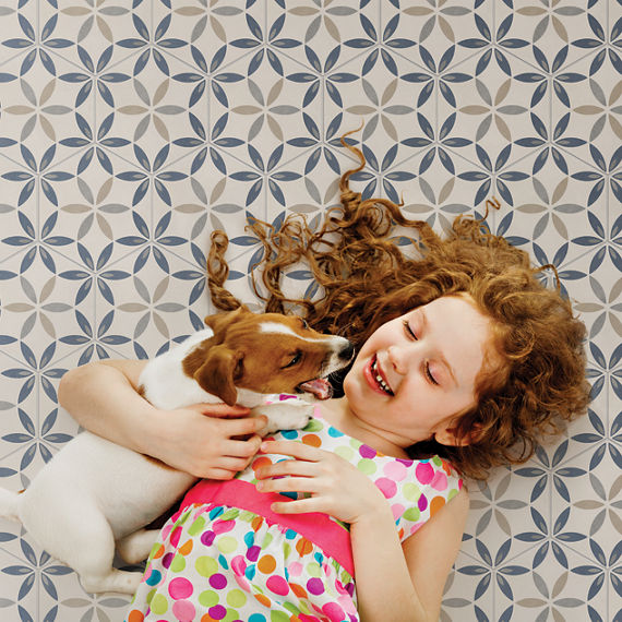 Girl with her pet laying on the concrete look encaustic tile.