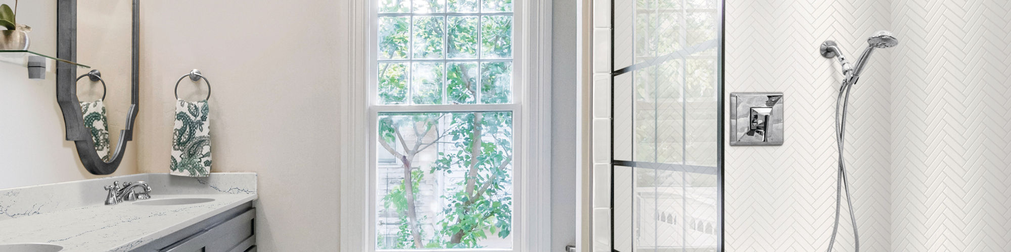 Bathroom with white rectangle wall tile on shower walls in herringbone pattern, gray hexagon mosaic tile on shower floor, and silver accents.