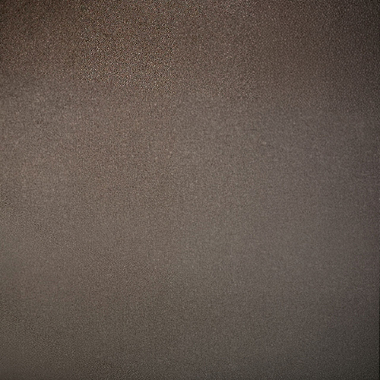 Image of a uniform brown textured surface filling the entire frame. The material appears slightly rough with a fine, consistent grain pattern. Lighting is soft and even, creating a muted, neutral appearance without strong highlights or shadows. The o