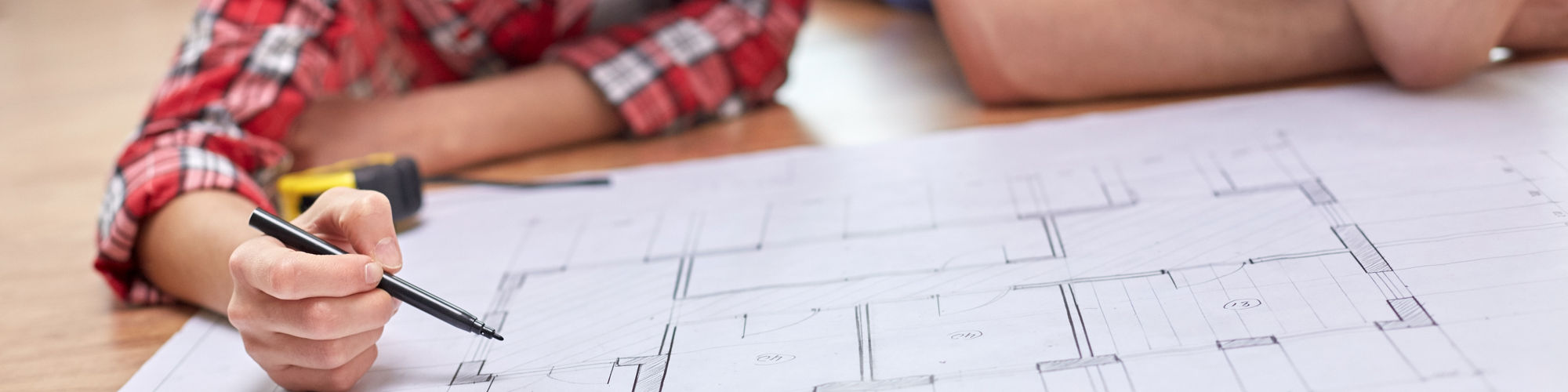 Close up of happy couple looking at blueprint at home