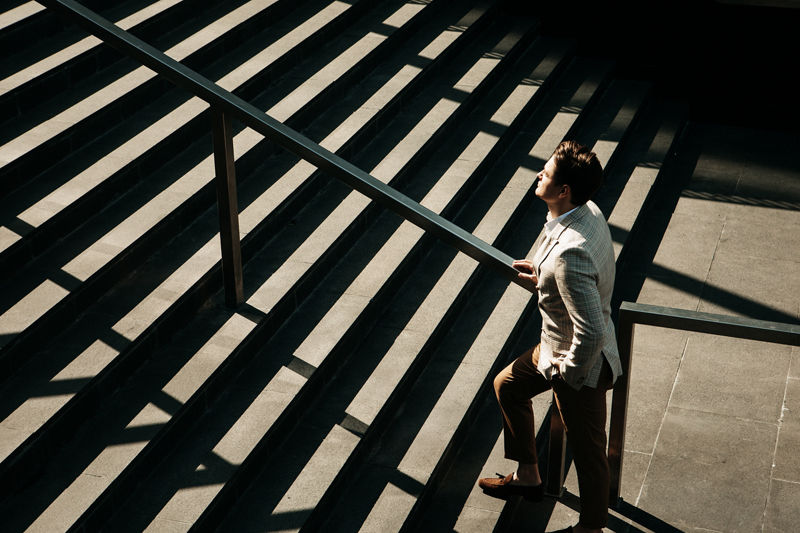 Business and people concept: Young Business man going up the stairs, summer day
