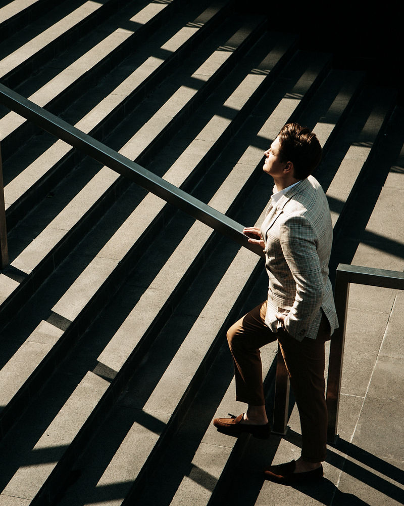 Business and people concept: Young Business man going up the stairs, summer day
