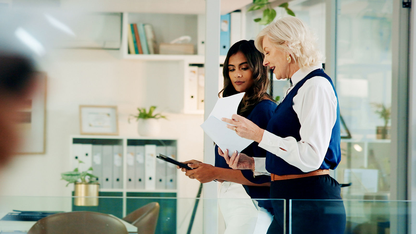 Business women, talk and office with walk, collaboration and paperwork from teamwork and discussion. Lawyer, conversation and attorney workers together with diversity of professional team at law firm.