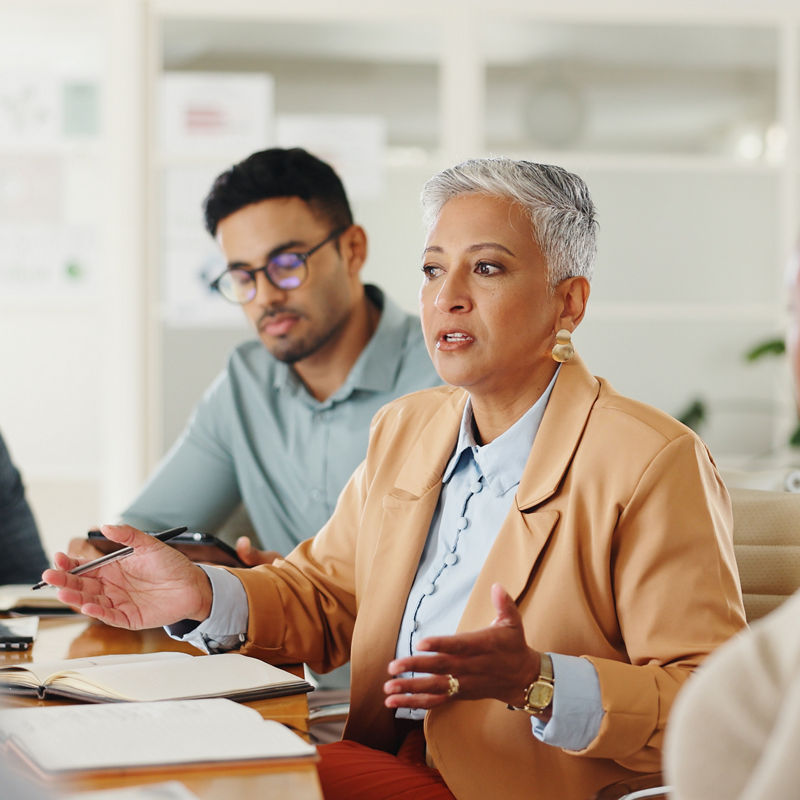 Senior, woman or business people in meeting with talking in teamwork for creative decision making. Collaboration, manager or professional employees with paperwork for project brainstorming in office.