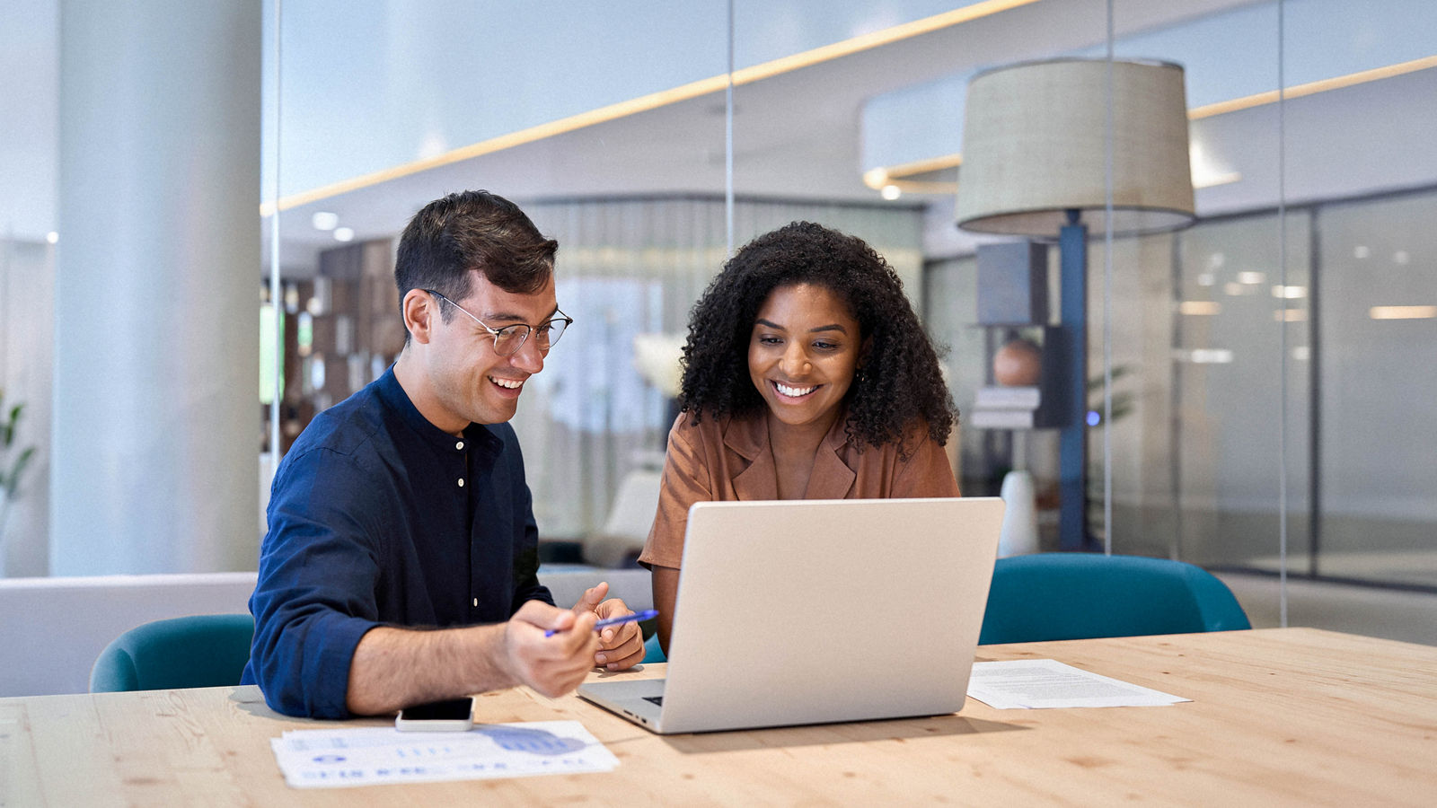 Smiling professionals working together on computer in an office