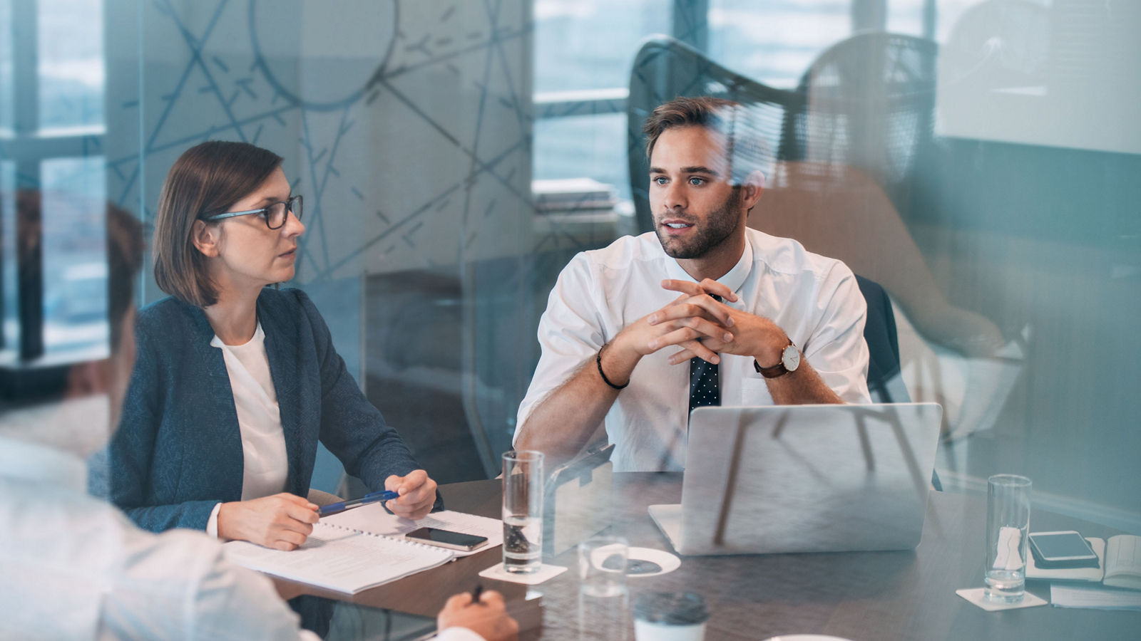 Group of successful businesspeople talking together while working around a table in an office boardroom
