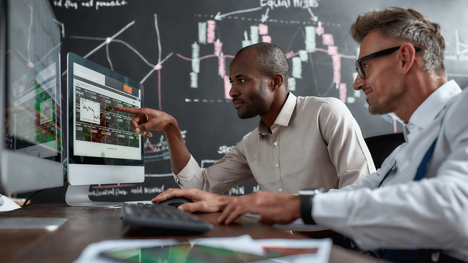 Two colleagues talking to each other, looking at graphs
