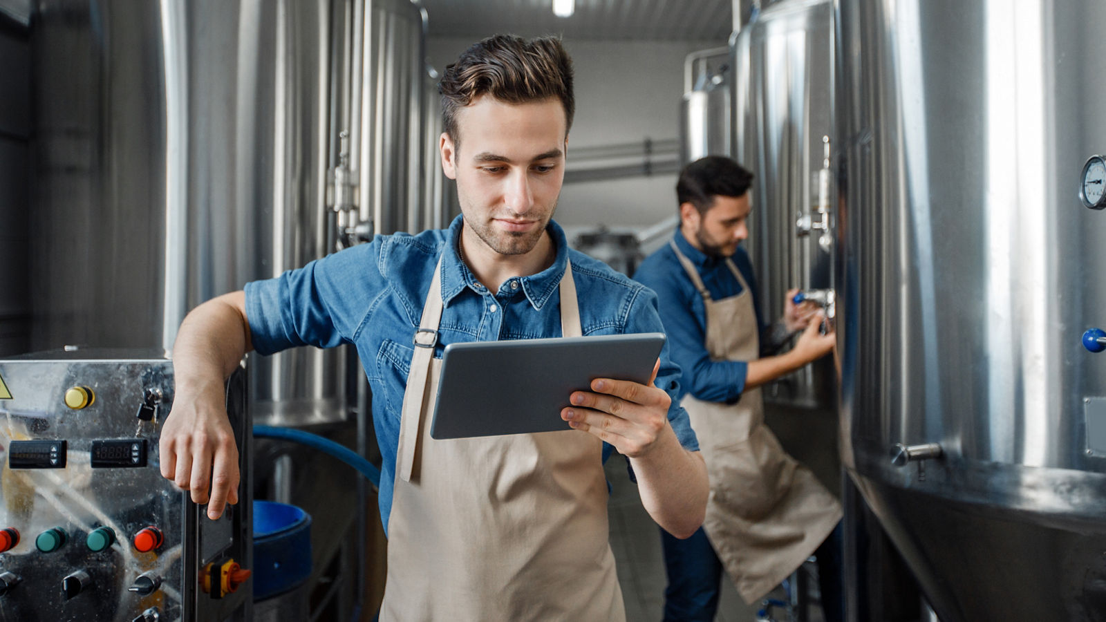 Small business owner looking at tablet in factory