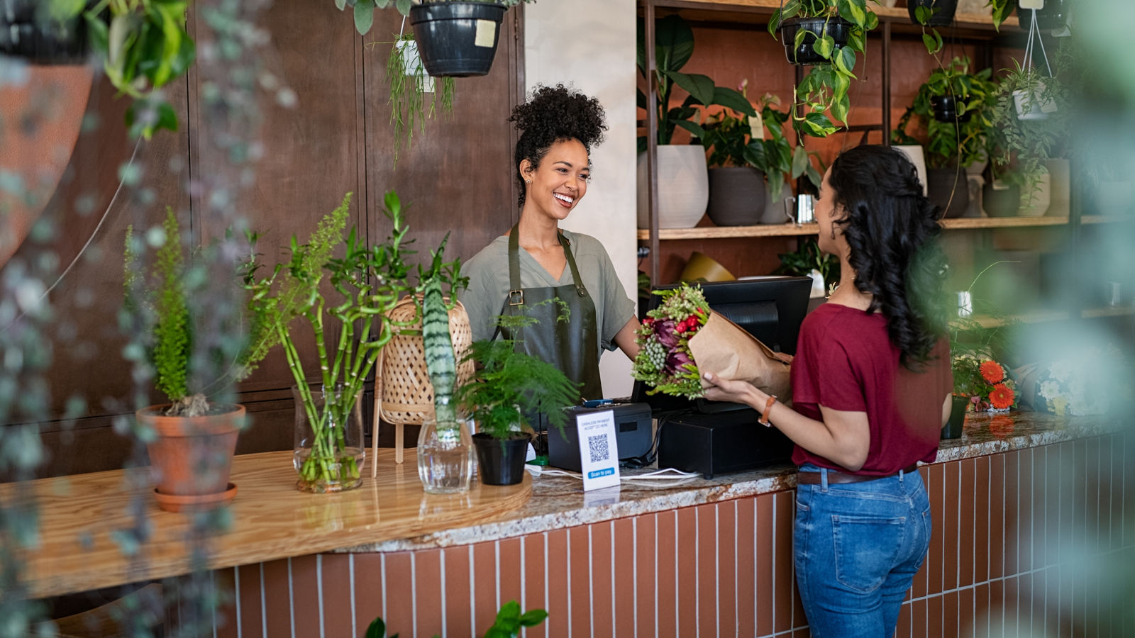 Small business owner in flower shop selling to customer