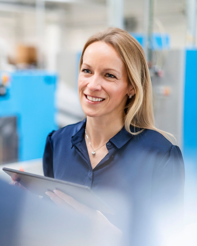 Happy businesswoman discussing with businessman in factory