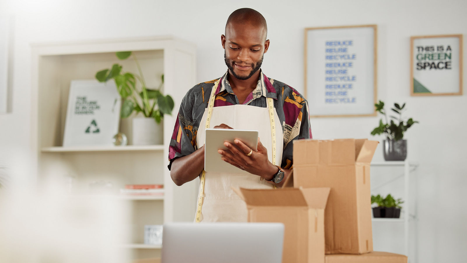 . Small business owner or creative startup entrepreneur checking an online order. Fashion, style and design with a trendy designer and tailor working on a tablet in his textile workshop or studio