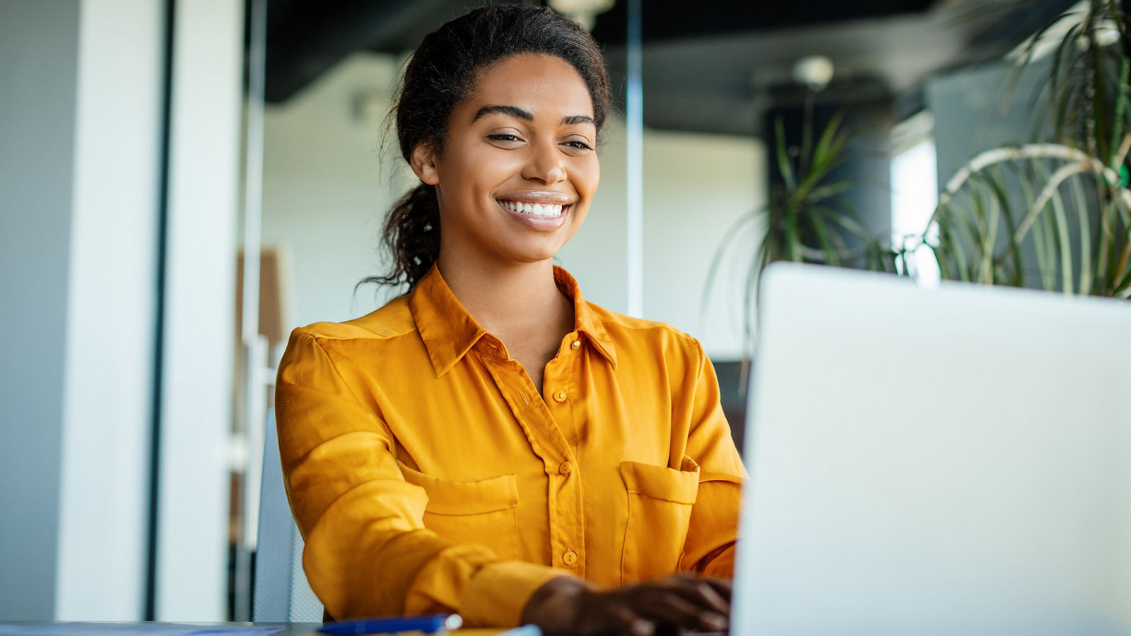 Happy businesswoman using laptop in office