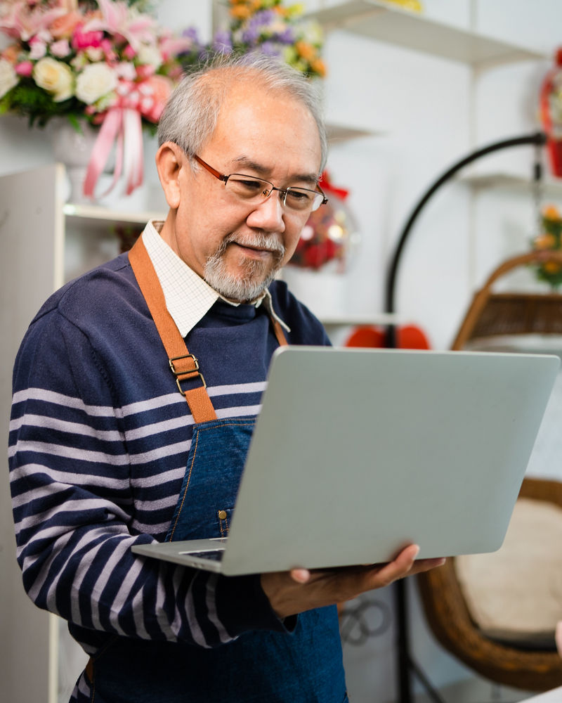 Small business owner using laptop at floral shop