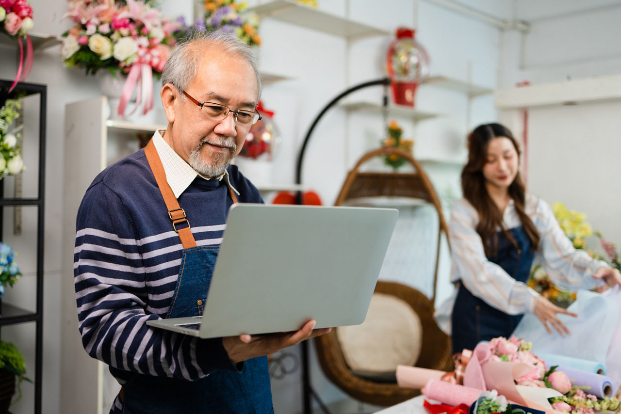 Small business owner using laptop at floral shop