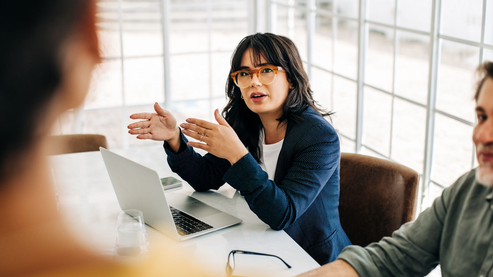 Professional woman talking to her team in an office meeting. Young business woman having a discussion with her colleagues. Group of business professionals brainstorming in an office.
