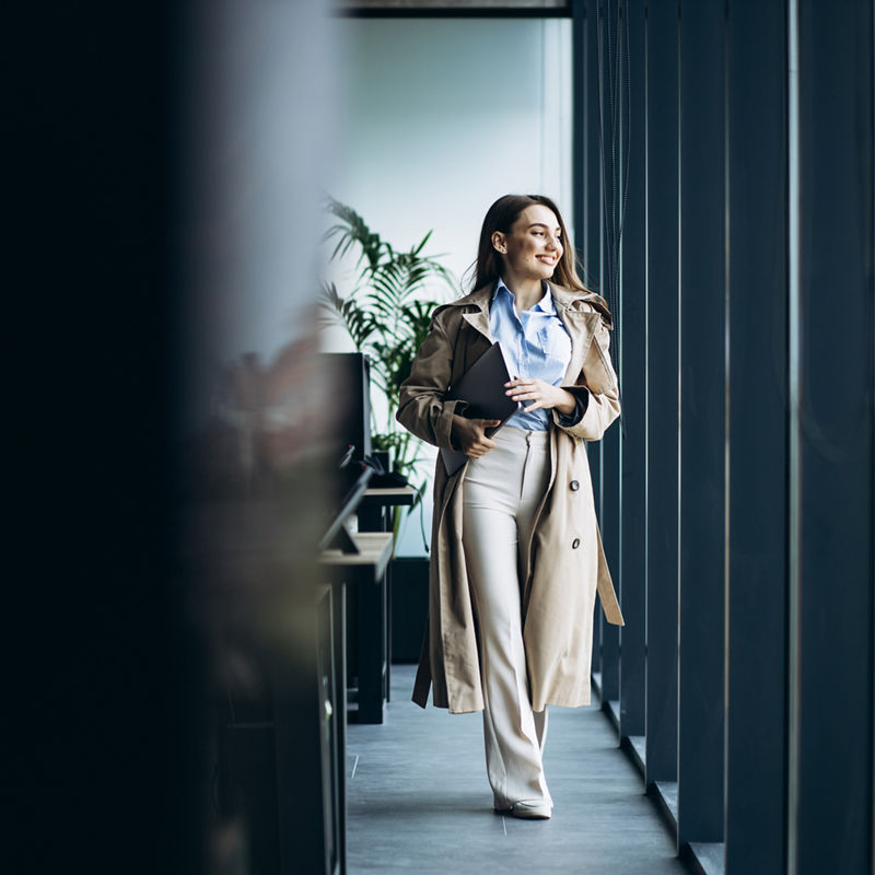 Business woman walking at the office building holding documents and folders