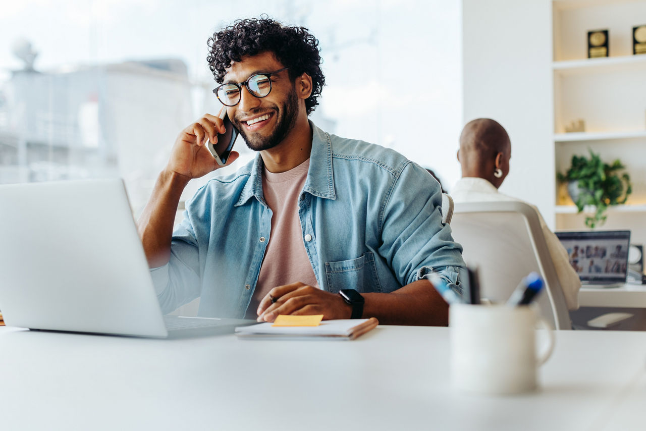 Business man smiling on laptop on phone