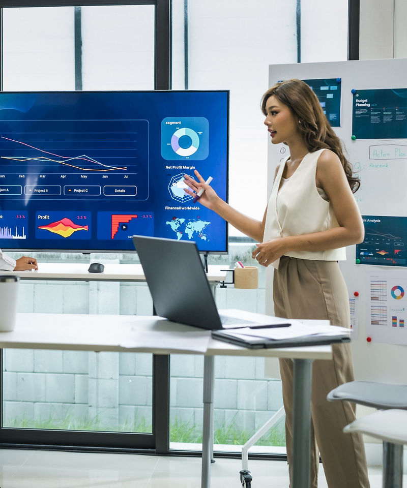 Woman leader presenting data and strategies in a modern office