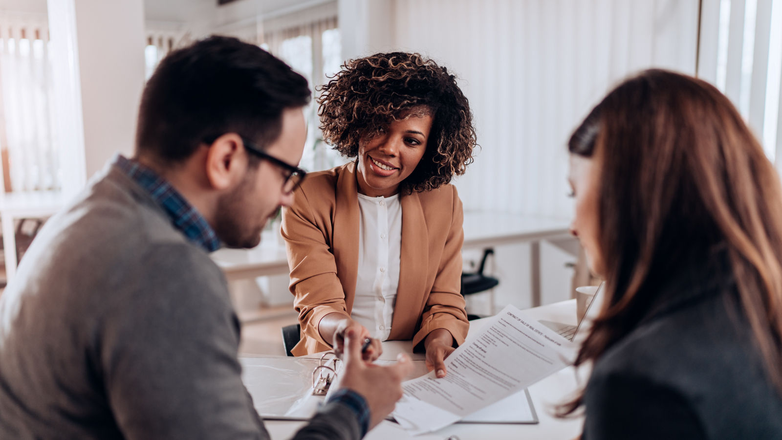 Woman handing couple paperwork to sign