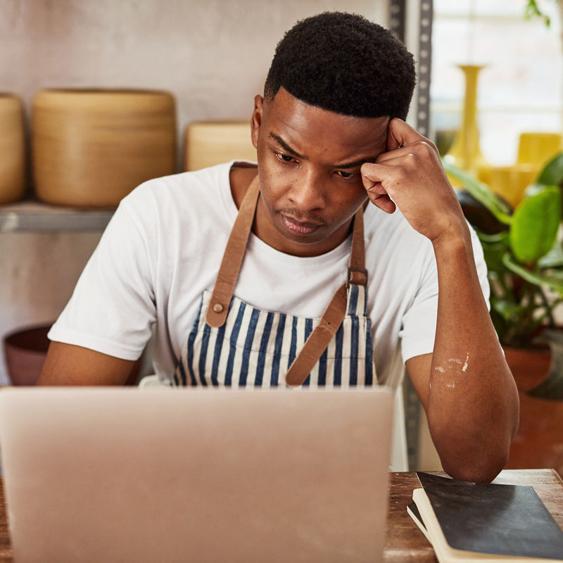 Business owner using a laptop while working in a ceramic studio