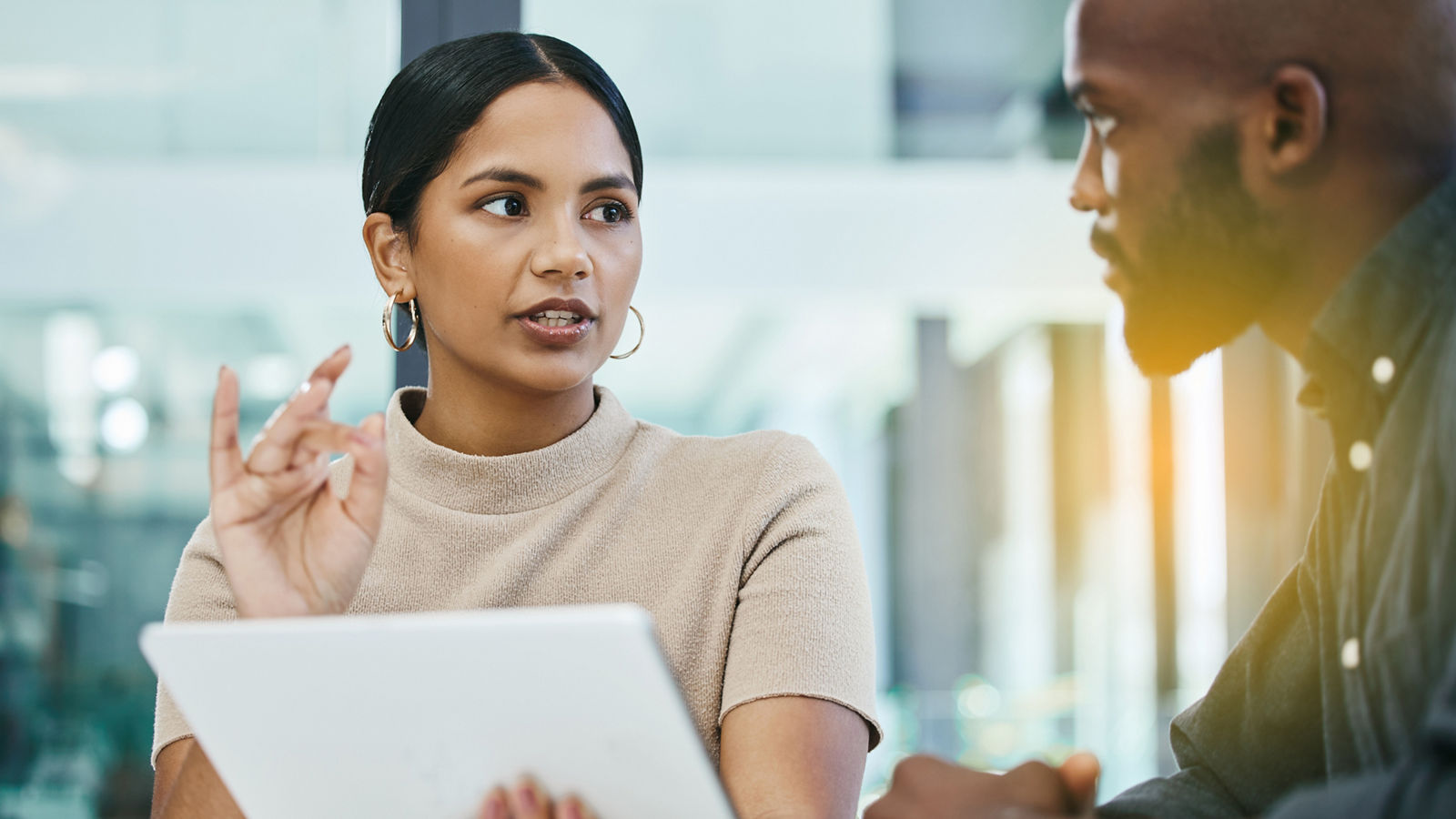 Business woman explaining business operations to man at desk
