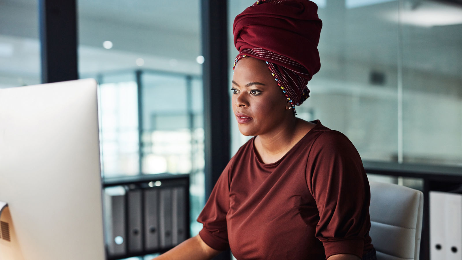 Woman with headscarf in office looking at computer