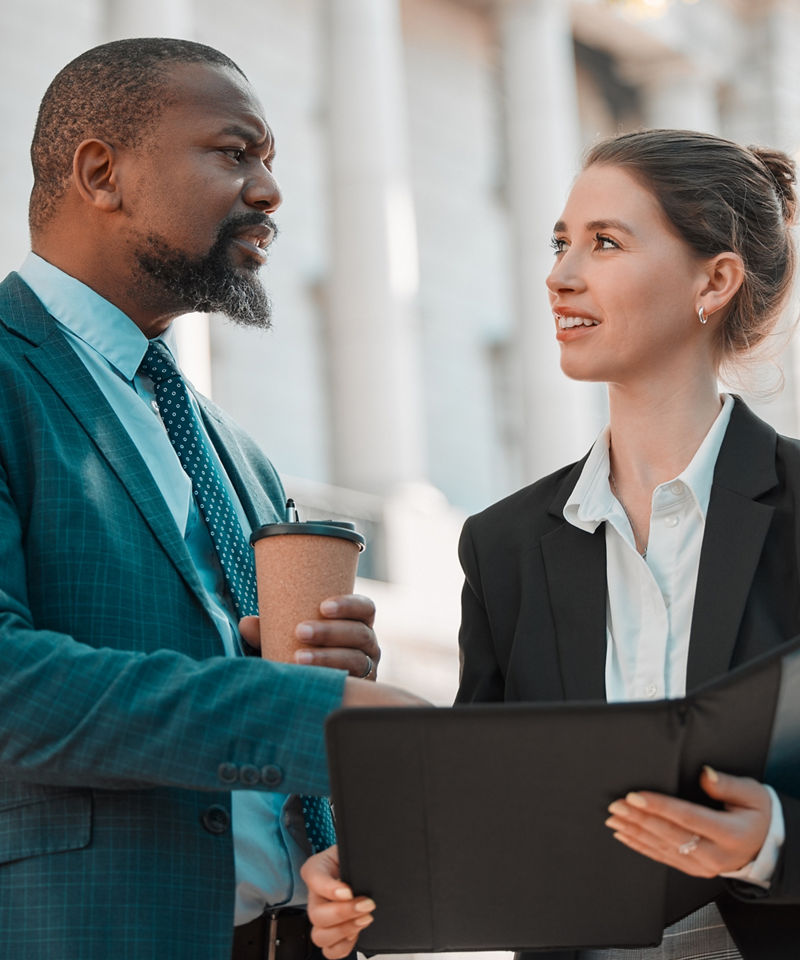 Business woman and man speaking outside of government building