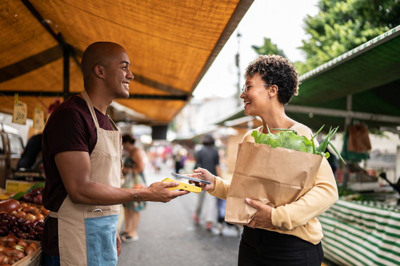 Small business owner checking customer out with phone