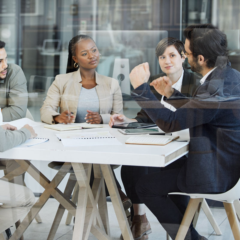 Business professionals having serious meeting at desk inside of office