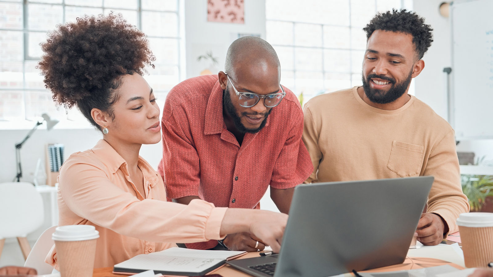 Group of marketers looking at computer smiling