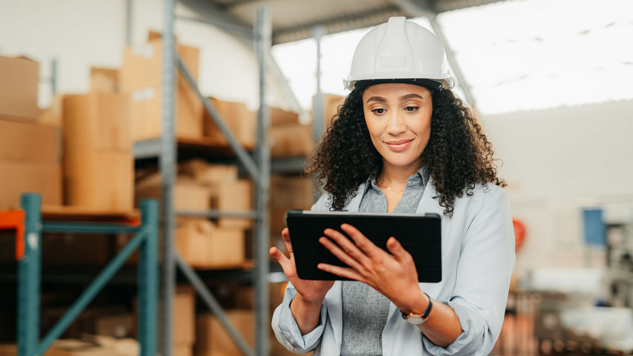  Business woman on tablet working in a warehouse