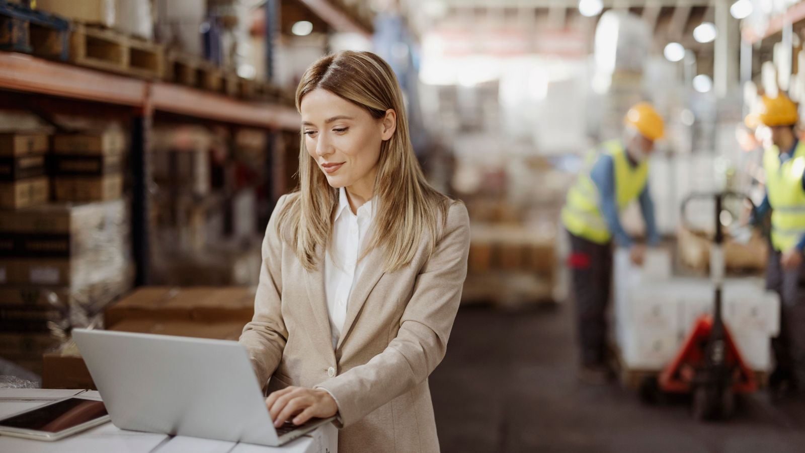 Female inventory manager working with computer laptop in storage warehouse. People, warehouse and industry concept