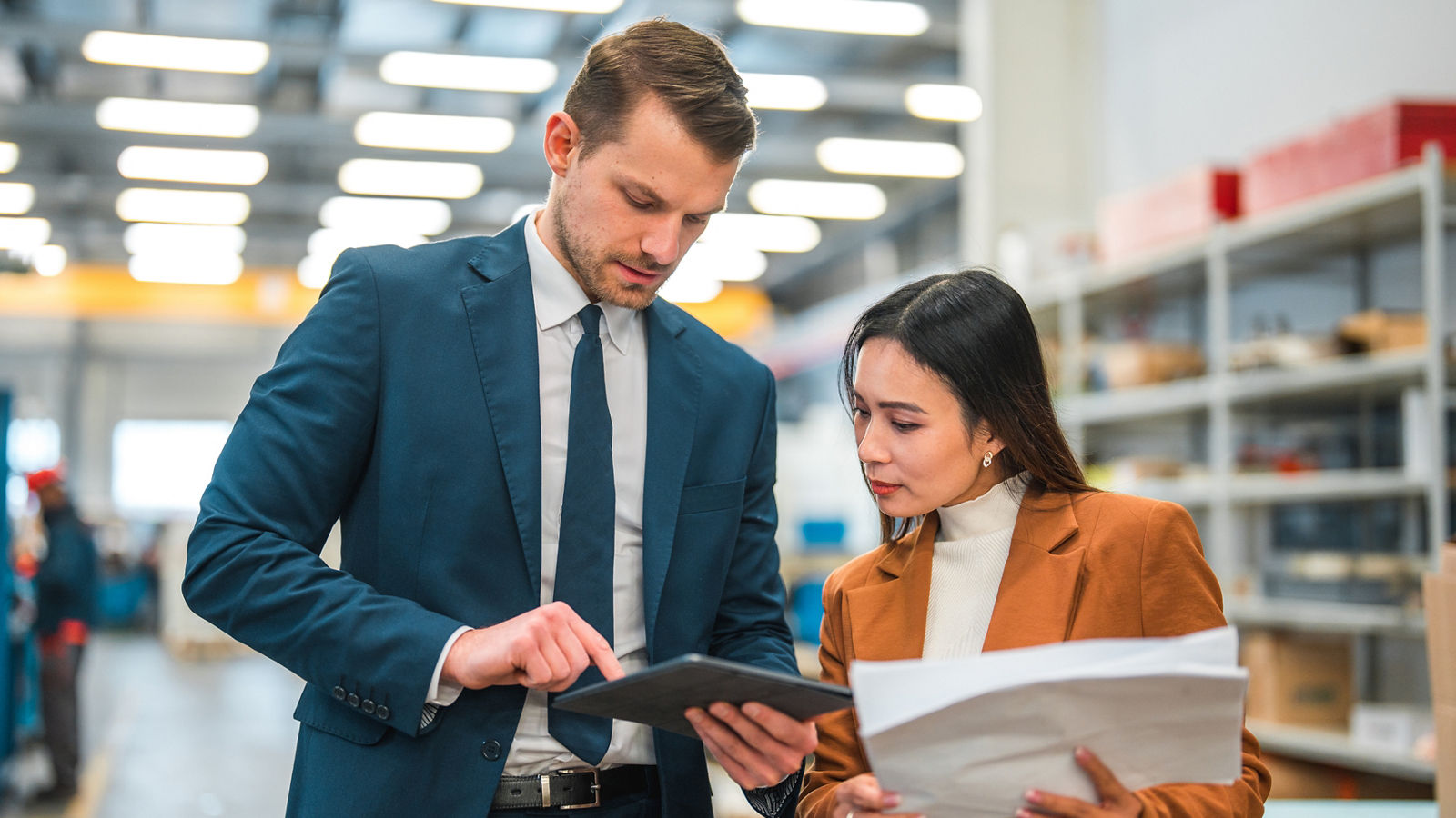 Warehouse managers in a business meeting looking at a touch screen tablet