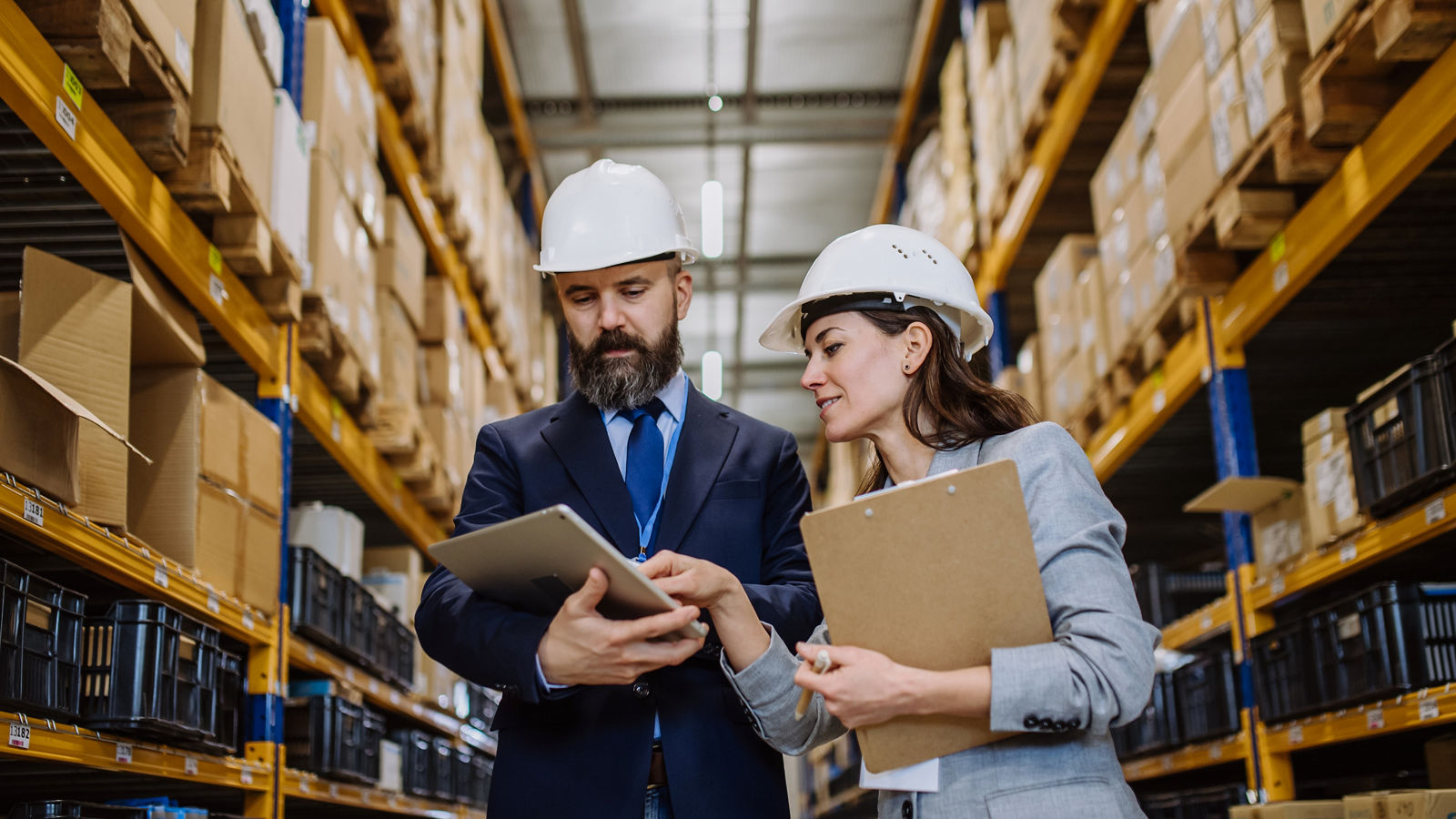 Two workers looking at tablet in warehouse
