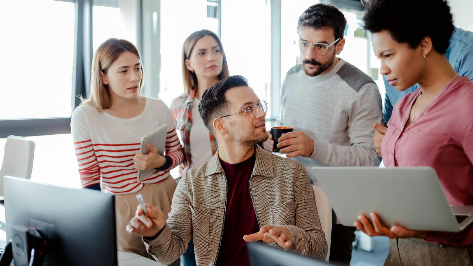 Software developers work in front of desktop computer in office