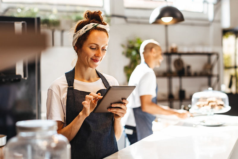 Cafe waitress using a digital tablet