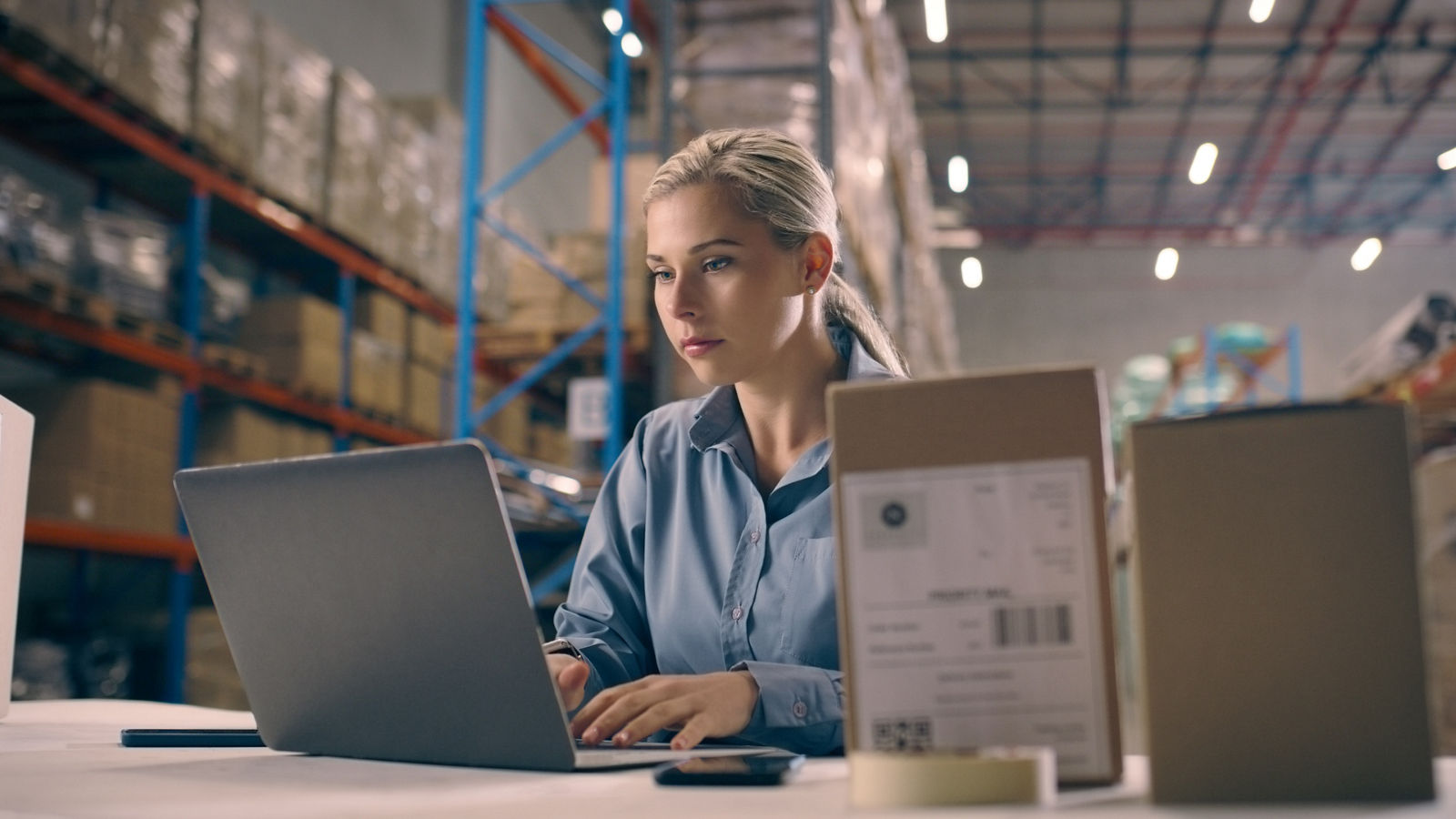 Business woman, laptop and box in supply chain, logistics or management in shipment control at warehouse