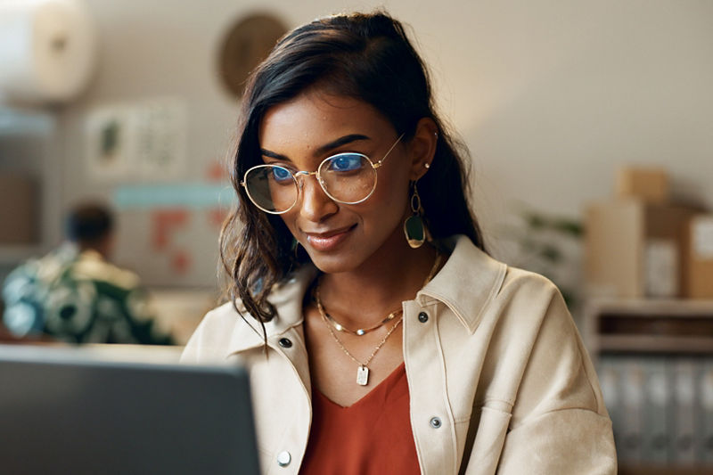 Woman on laptop in small business office room