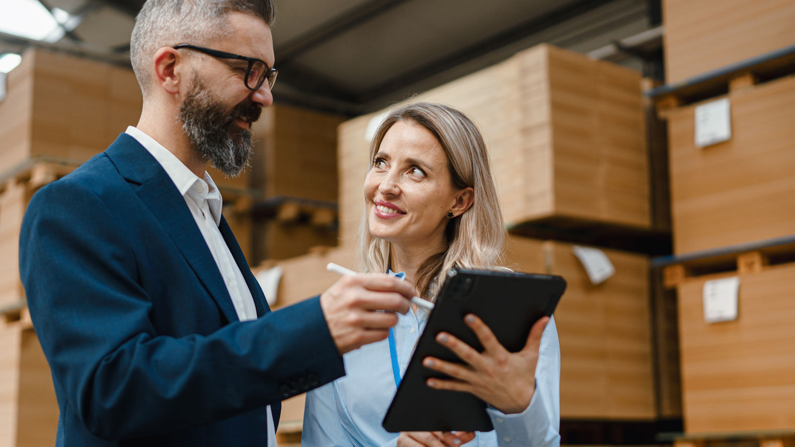 Two business people looking at tablet in warehouse