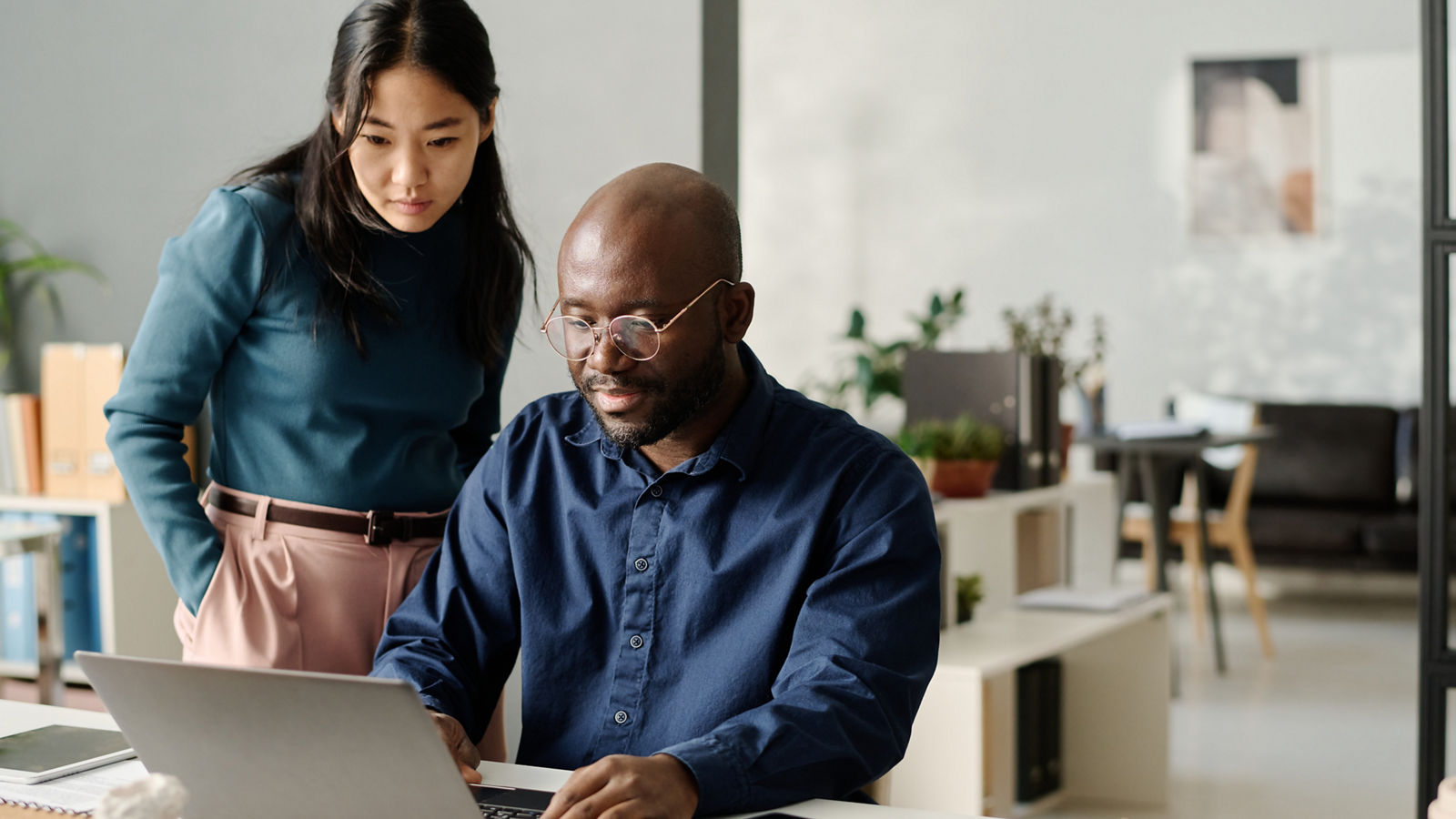Man and woman working on laptop in office