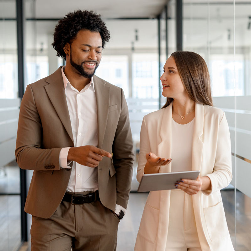 Investors walking through office discussing business while looking at laptop