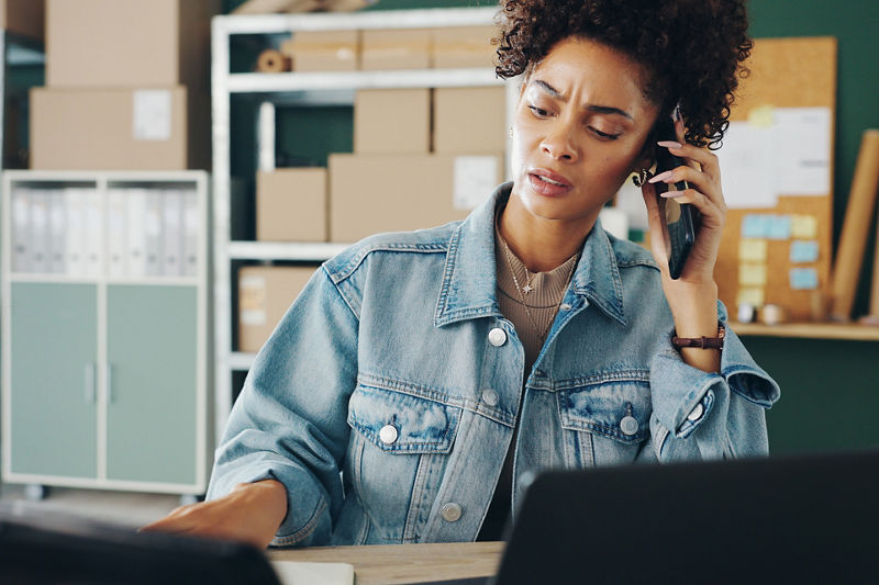 Talking, confused and woman with phone call, boxes and retail for ecommerce, laptop and shipping. Entrepreneur, owner and girl with computer, logistics and frustrated of sales and communication