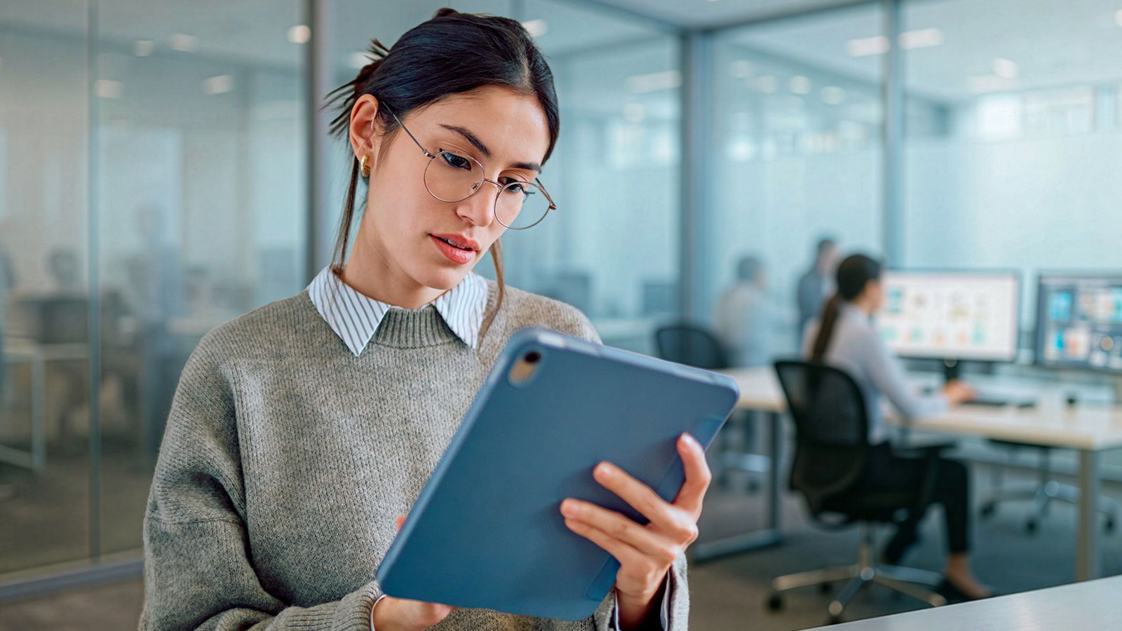 Woman in computer office looking at tablet