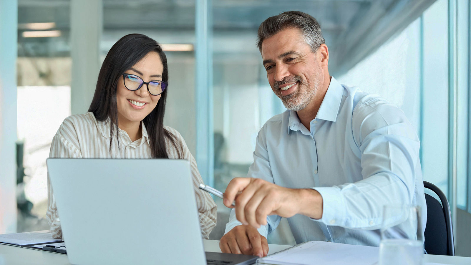 A picture of two finance workers looking at their computer
