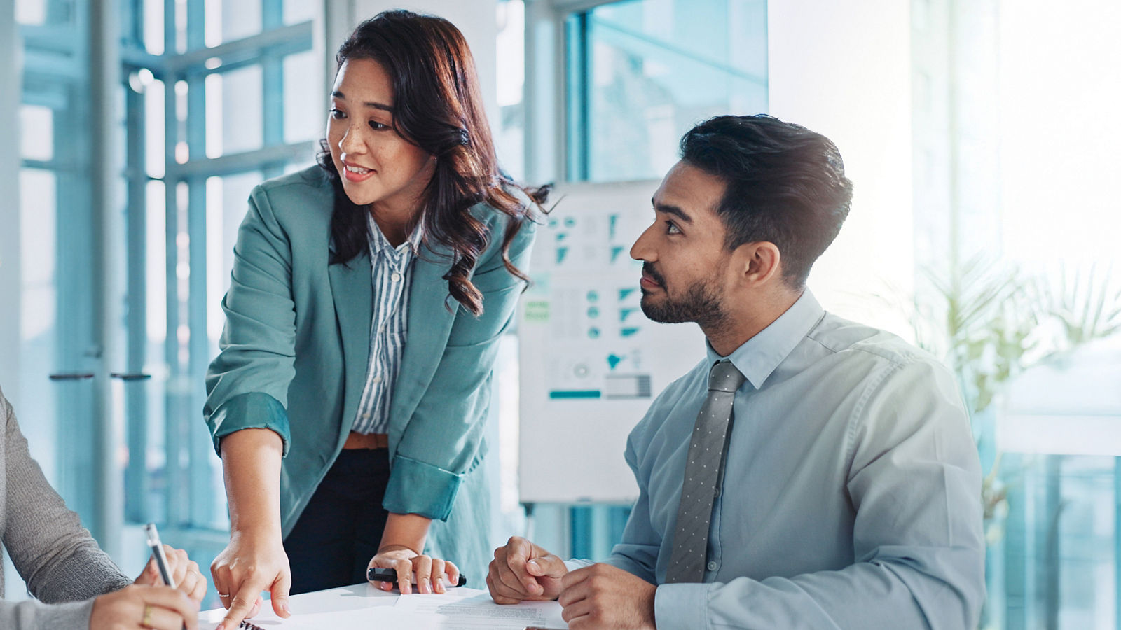 A picture of two data analysts speaking with client across table